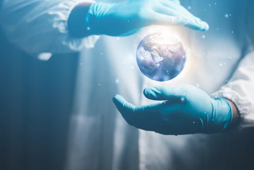 Ein Medizinforscher umfasst eine Weltkugel. Symbolbild für Nachhaltigkeit bei STÜKEN.